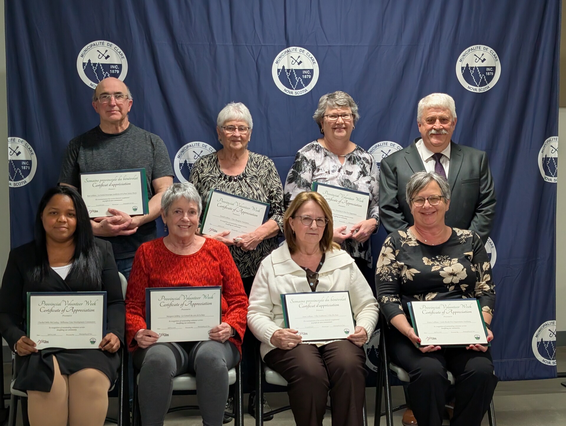 De gauche à droite: Rangée arrière: Jean LeBlanc, Grace LeBlanc , Christine Lewis, Sous-préfet Eric Pothier. Rangée avant: Claribel Bello McCauley, Margaret Jeddry, Anne LeBlanc, Elaine LeBlanc.