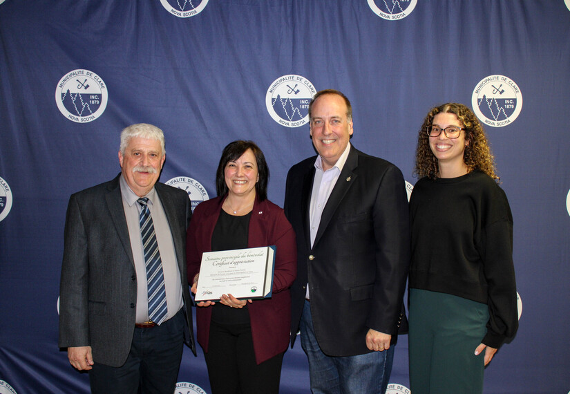 A picutre of Deputy Warden Eric Pothier, Volunteer of the Year Monette Boudreau, MP Chris d'Entremont and Daralyn Comeau on behalf of MLA Ryan Robicheau in front of a navy blue backdrop with white Municipality of Clare logos on it.